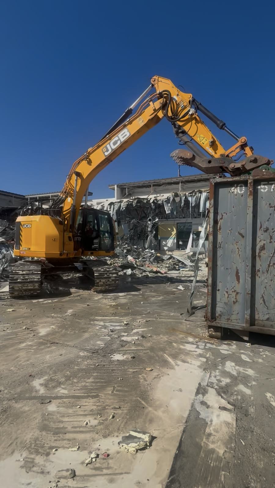 Volpe Demo excavator loading demolition debris into a container