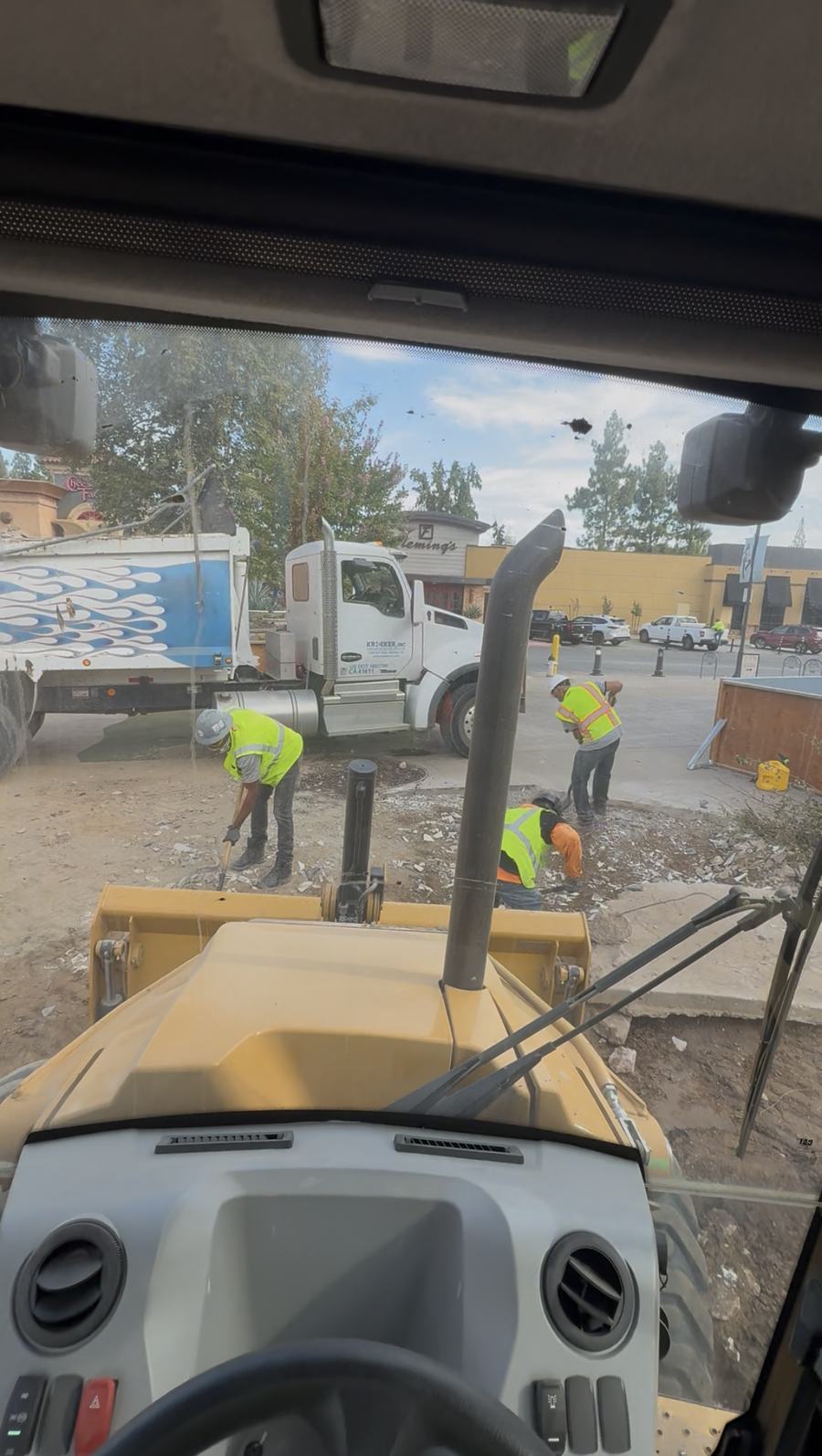 Crew in high-visibility vests beside a loader and dump truck